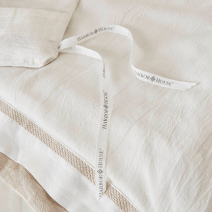 Premium white bedding with textured layers, soft linen material, and a Harbor House ribbon.